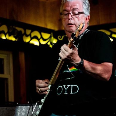 Older man passionately playing electric guitar indoors.