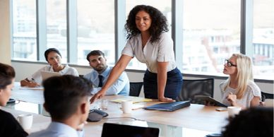 A confident woman leads a business meeting with attentive colleagues.