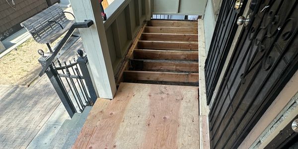 Wooden floor repair in progress on a porch staircase.