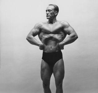 Black and white photo of a male bodybuilder posing.