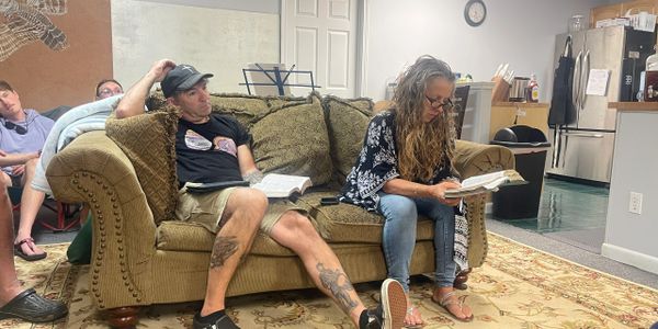 People reading books in a casual living room setting.