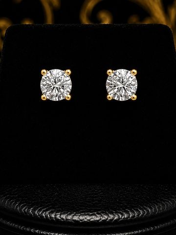 Brincos de diamante redondos com suporte dourado.