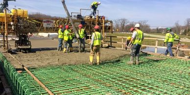 Construction workers pouring concrete at a site.