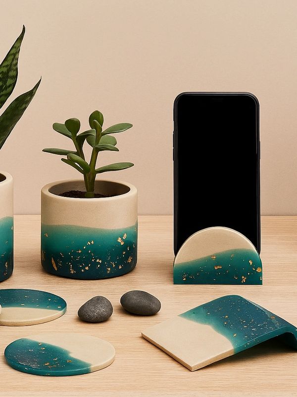 Elegant desk setup with potted plants, coasters, phone stand, and laptop.