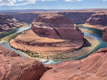 Horseshoe Bend river meander surrounded by red rock formations.