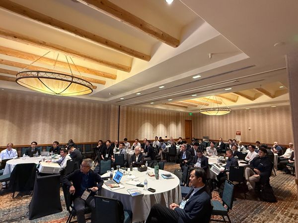 Group of people attending a conference in a large room.