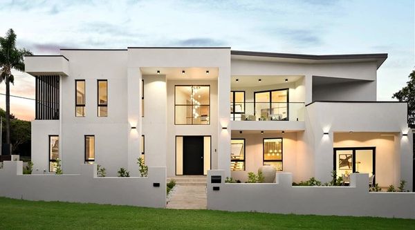 Modern white two-story house with large windows and a well-lit entrance.