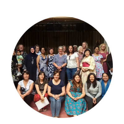 a group of women of different ages and ethnicities sit and stand together smiling