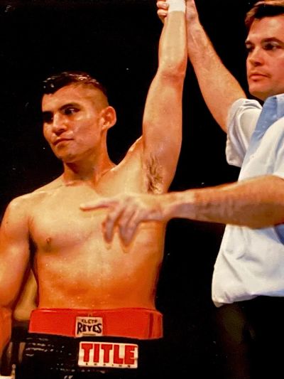 Boxer wins as referee raises his arm.