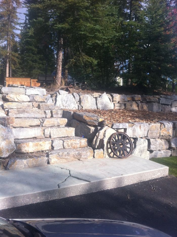 Two tier retaining wall with natural rock steps