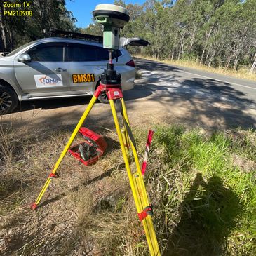 Static GNSS survey set up with survey vehicle in the background