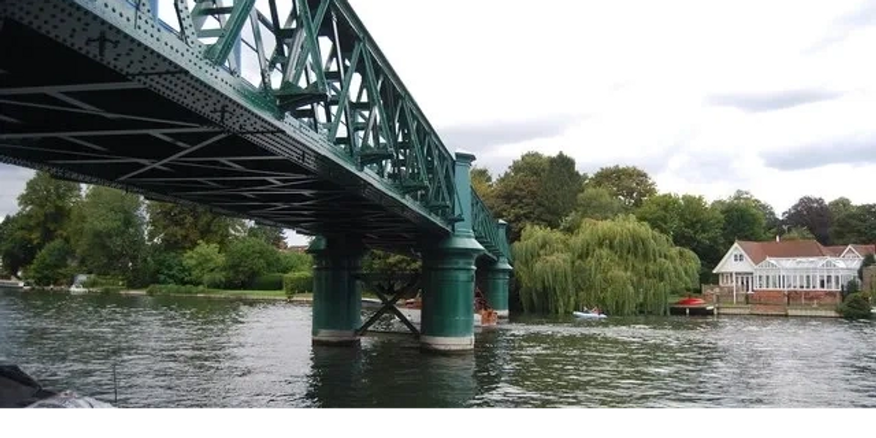 Scenic view of the River Thames at Bourne End with the iconic green railway and footbridge. 