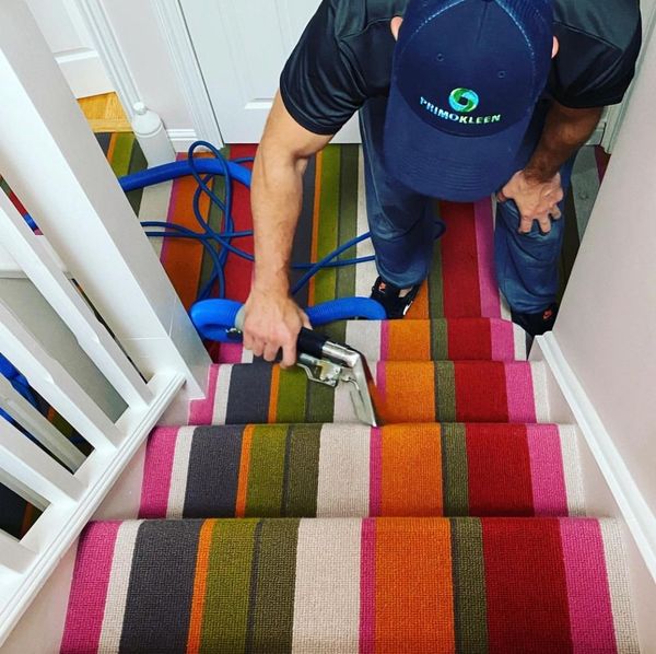 Ed the owner of Primokleen, cleaning striped stairs in a Maidenhead home.