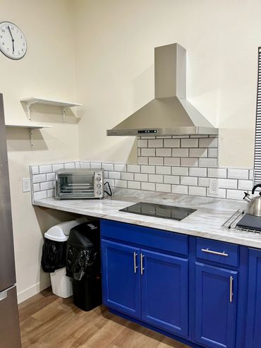 Modern kitchen corner with blue cabinets and stainless steel appliances.