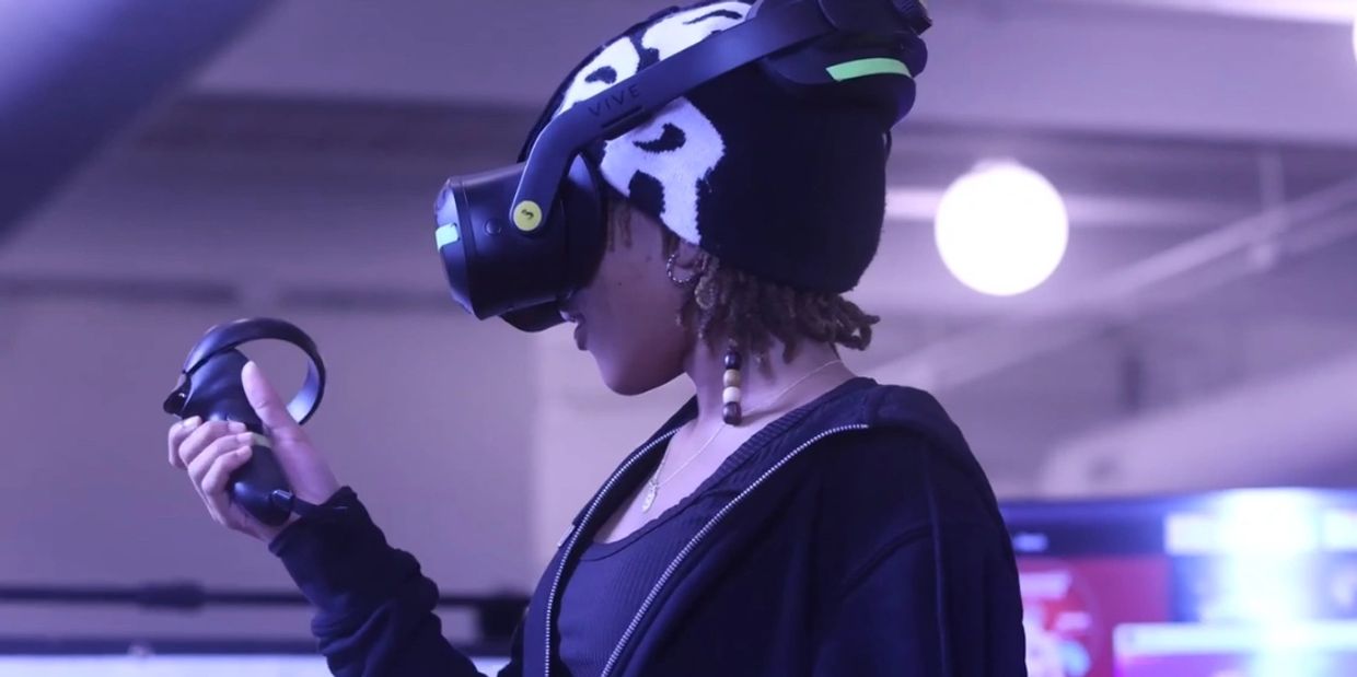Person wearing a VR headset and holding a controller indoors.