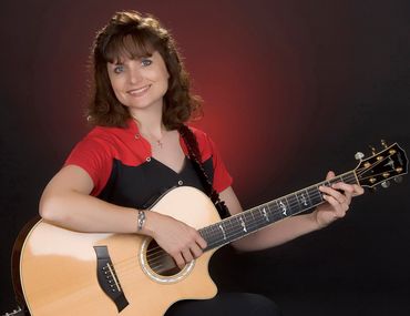 Sandy Lusco Playing an Acoustic Guitar