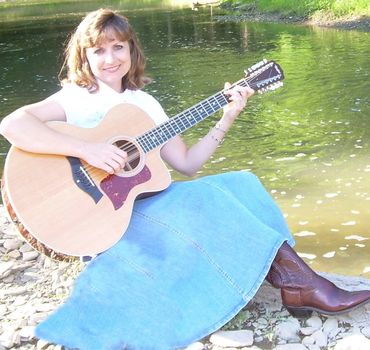 Sandy Lusco Playing an Acoustic Guitar