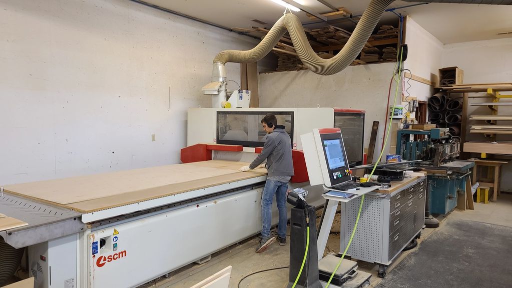 Person operating a woodworking machine in a workshop.