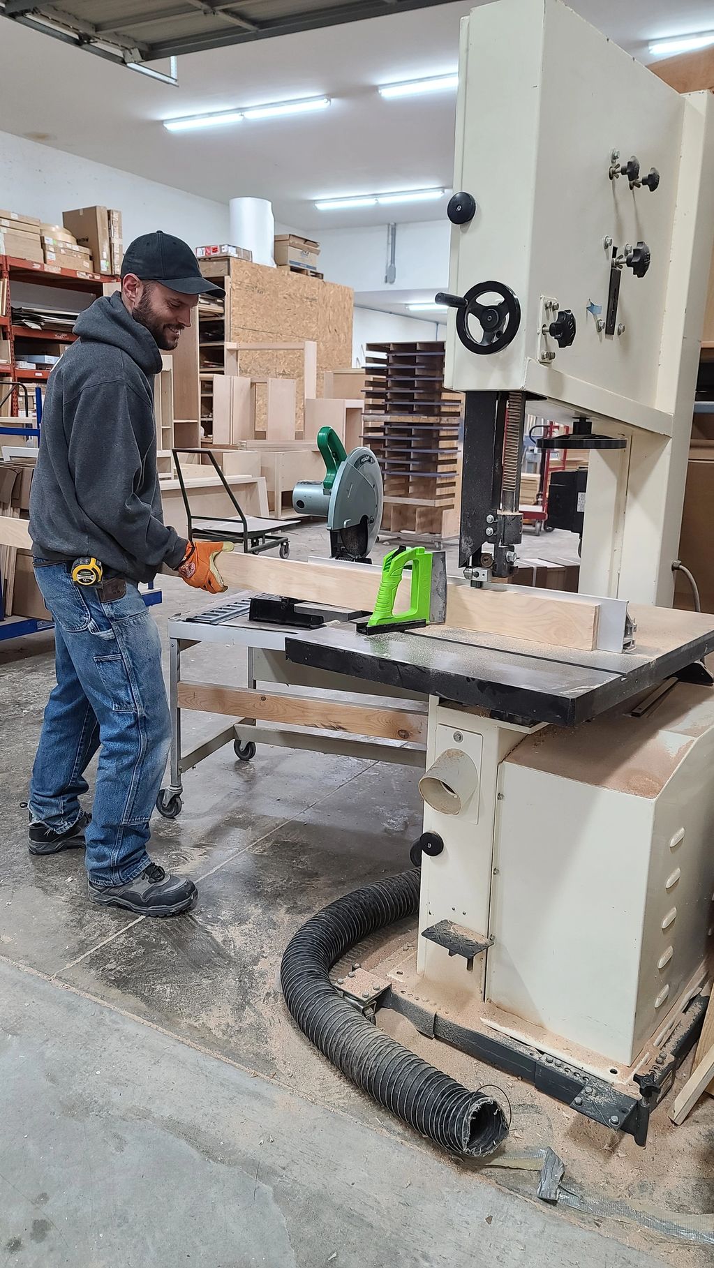 Man working in a woodworking shop using a bandsaw.