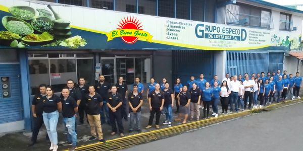 Grupo de empleados posando frente a una empresa en Costa Rica.
