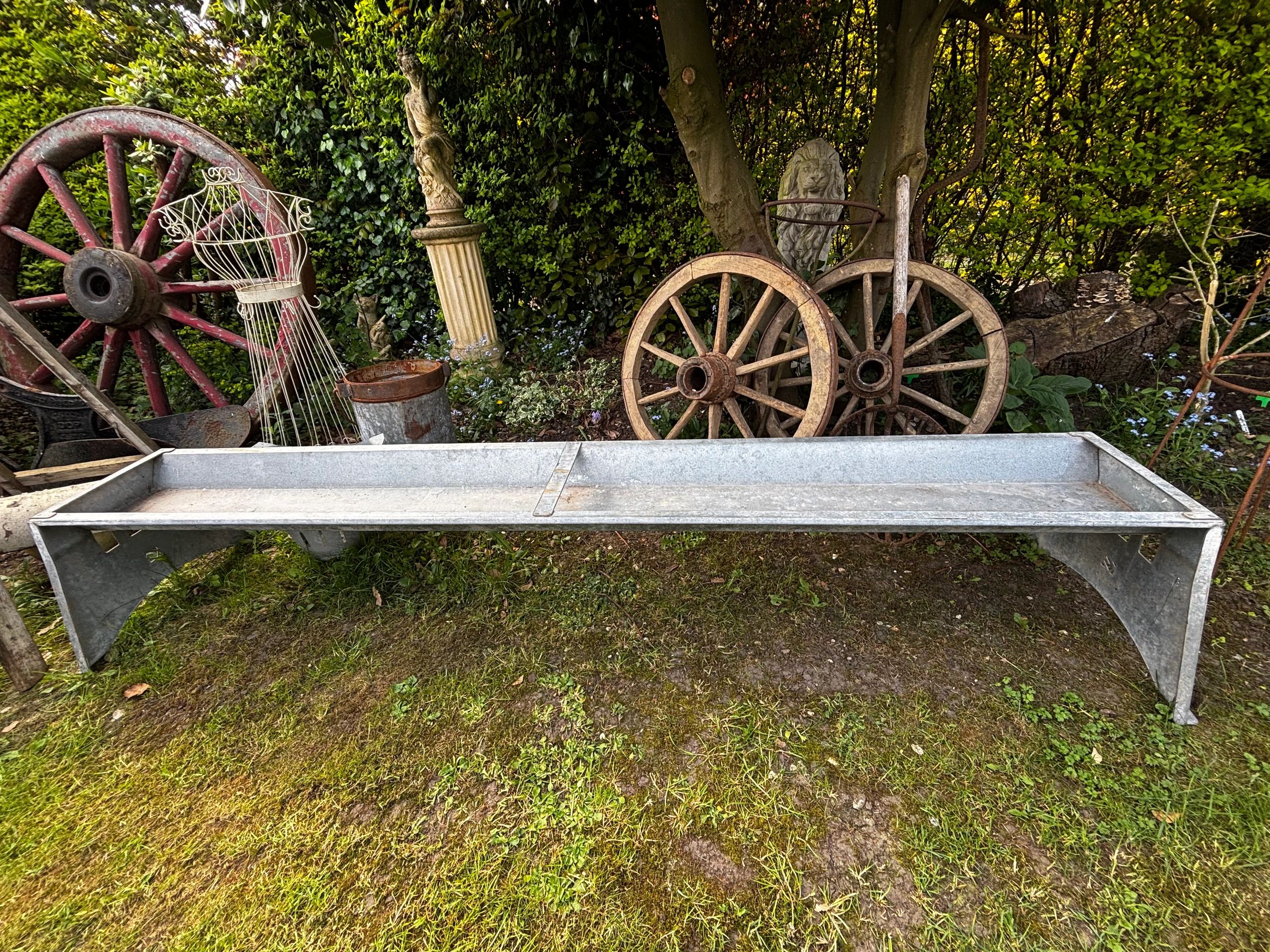 Rustic garden scene with wagon wheels and decorative items.