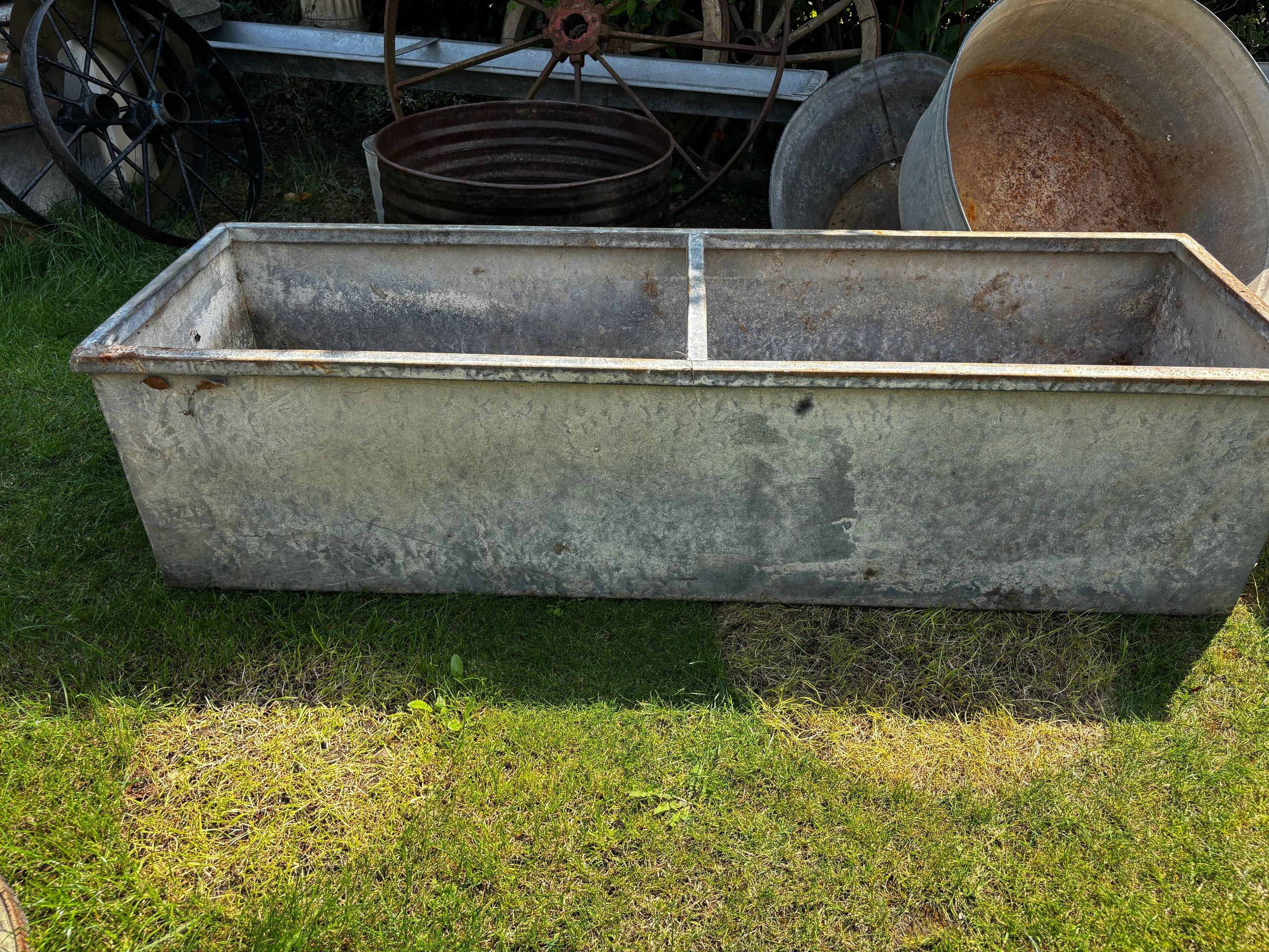 Old metal trough with wheels in the background.