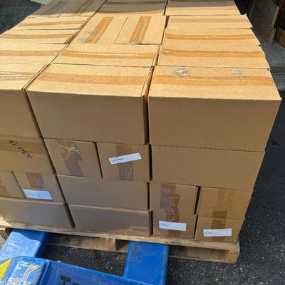 Stack of sealed cardboard boxes on a wooden pallet outdoors.