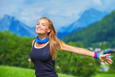A woman enjoying fresh air outdoors with mountains in the background.