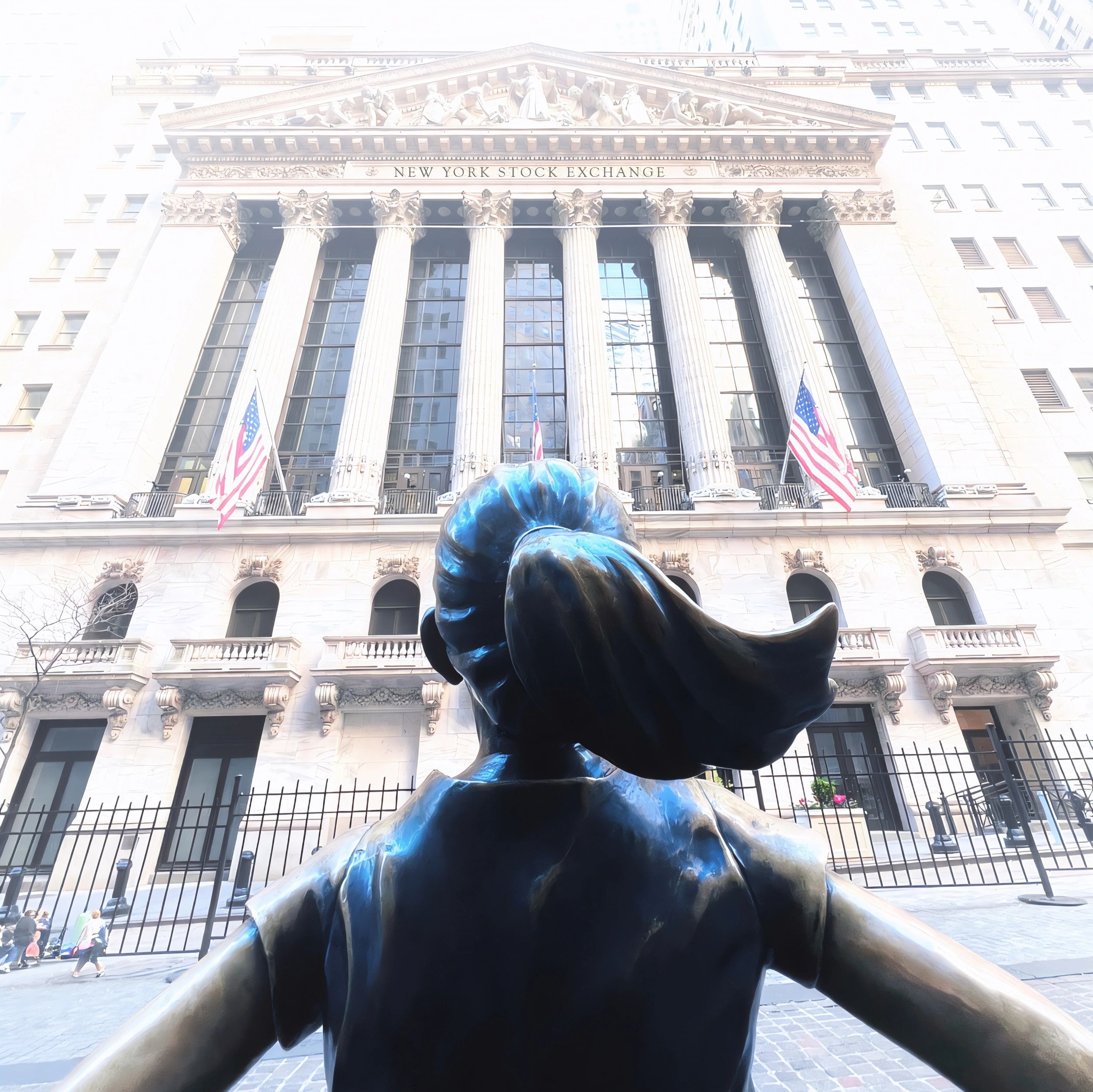 View from behind the Fearless Girl statue facing the New York Stock Exchange building.
