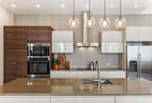 Modern kitchen with sleek cabinetry, stainless steel appliances, and pendant lighting.