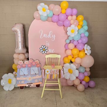 Customized backdrop and balloons for groovy-themed first birthday party.