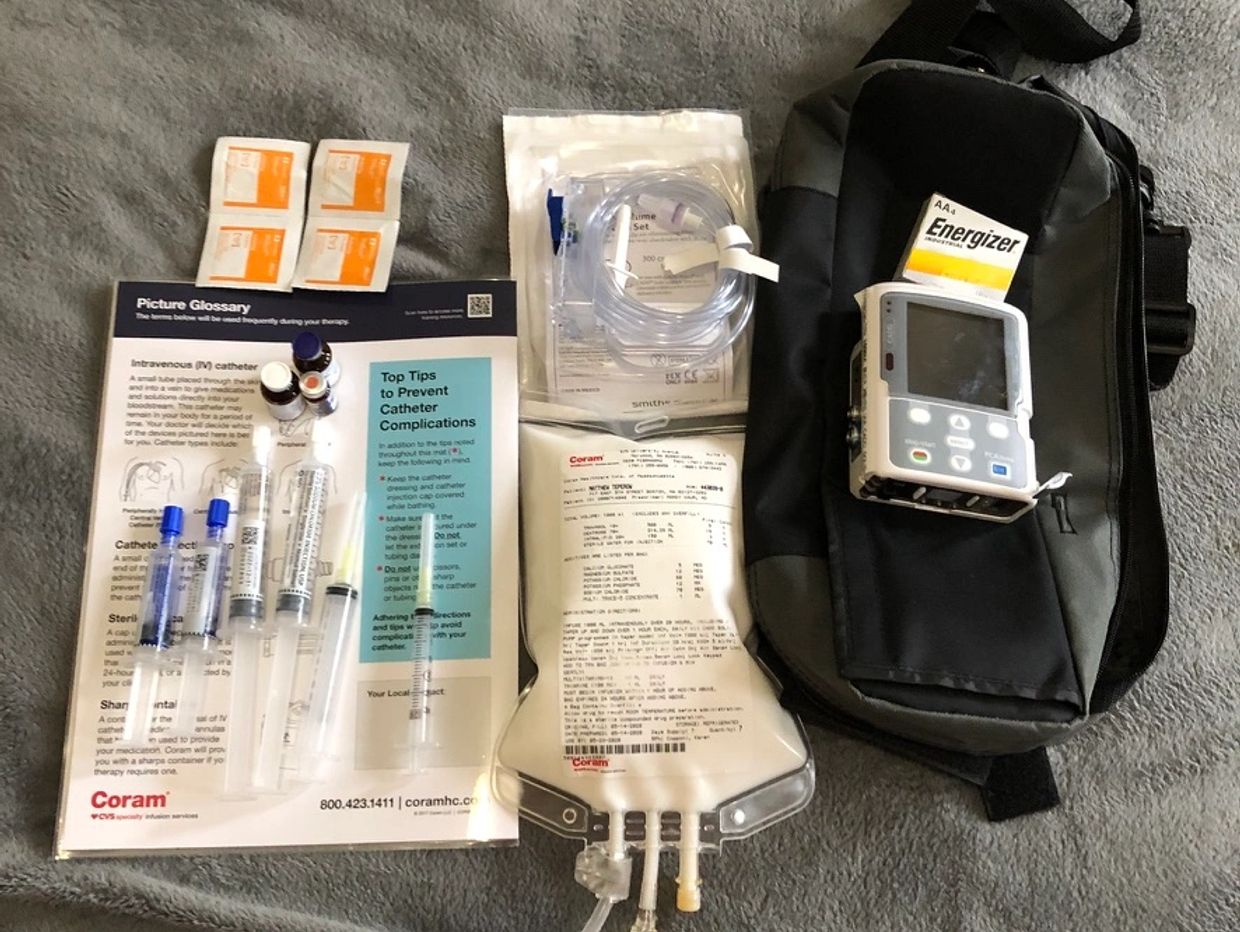 Medical IV therapy kit with syringes, IV bag, tubing, and infusion pump.