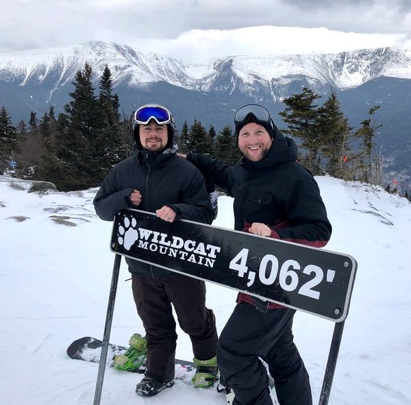 Two snowboarders posing at Wildcat Mountain summit at 4,062 feet.