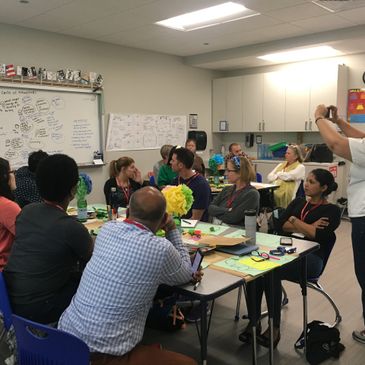 Adults engaged in a workshop or meeting in a classroom setting.
