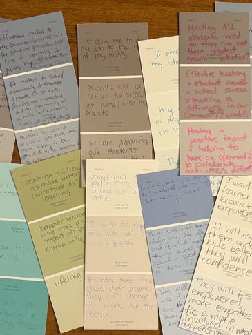 Colorful sticky notes with handwritten educational goals and reflections on a wooden table.
