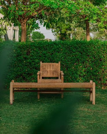 Wooden chair and bench in a green garden.