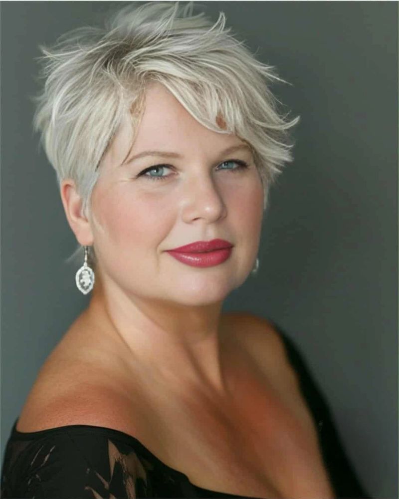Confident woman with short blonde hair and red lipstick in a black outfit.