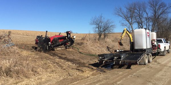 Installing trenchless fiber optic conduit underground.