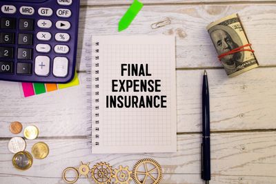 Notebook labeled “Final Expense Insurance” with money, coins, pen, and calculator on desk.