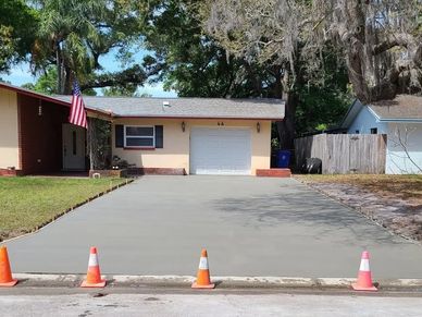 Freshly poured concrete driveway in front of a suburban house.