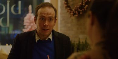 Man talking to a woman in a cozy setting.
