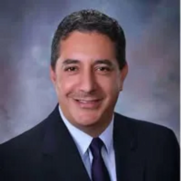 Professional portrait of a man in a suit and tie.