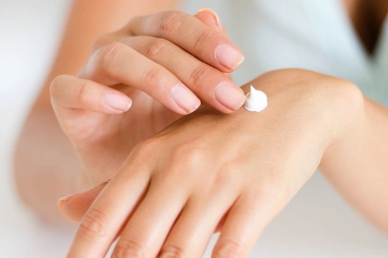 Woman applying CBD cream on her hand.