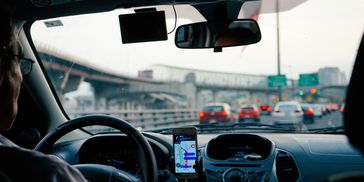 A car driver view a traffic signal near flyover and lot of cars are ahead. 