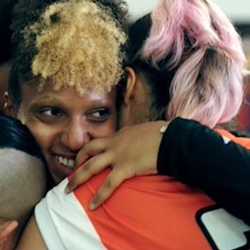 A group hug showing warmth and friendship among diverse individuals.