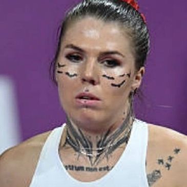 Woman with facial and neck tattoos.