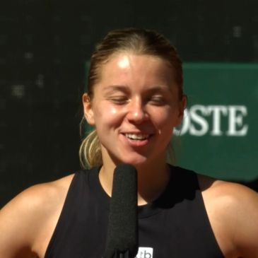 Young woman smiling during an interview with a microphone.