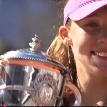 Smiling woman holding a silver trophy.