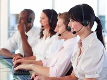 Customer service team wearing headsets working at computers.
