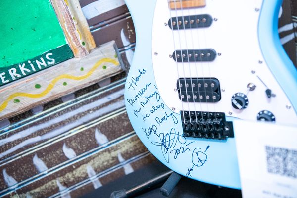 Light blue electric guitar with signatures on the body.